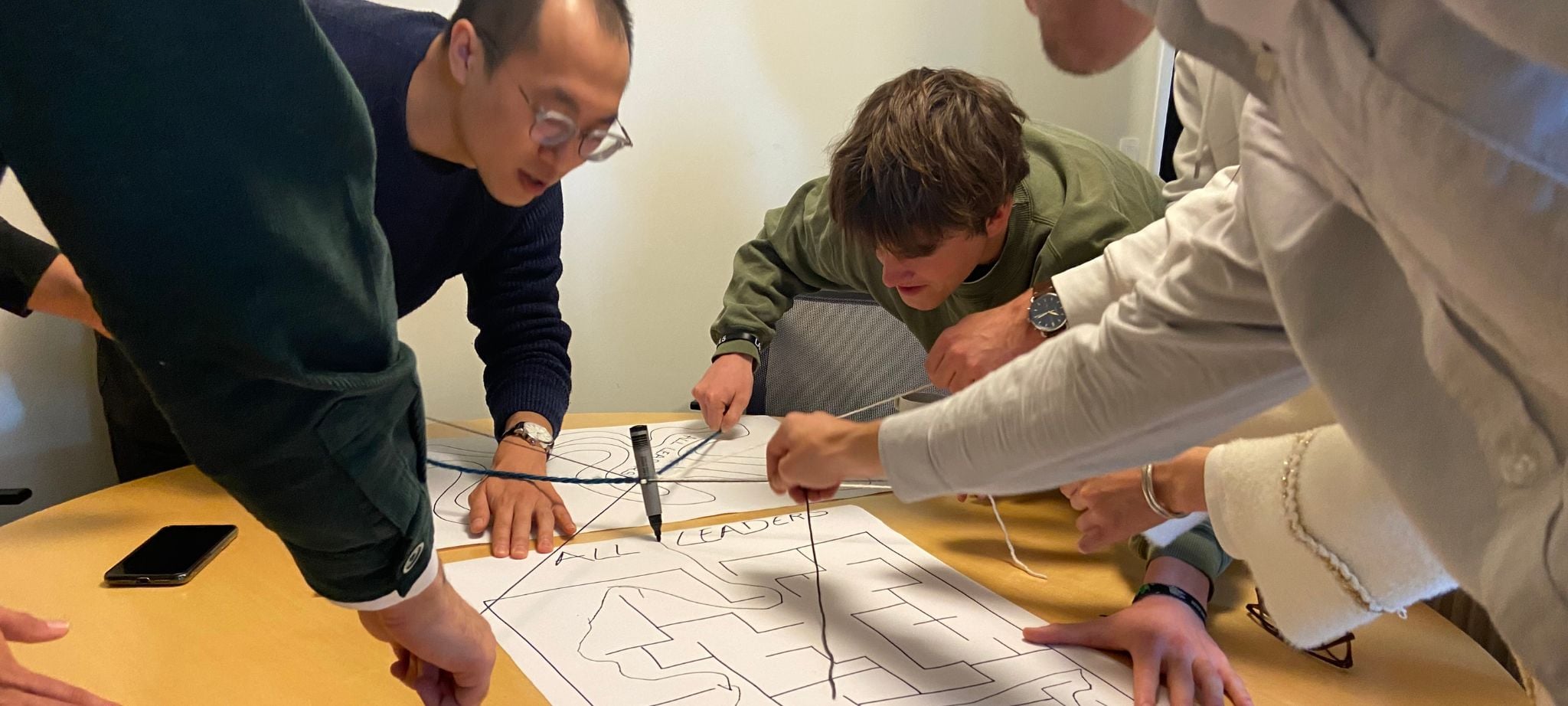Students work in groups testing leadership through an exercise 